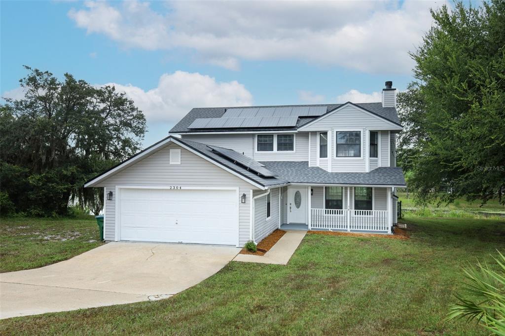 2304 Harding Circle Deltona, FL 32738 - Photo 1 of 1 a front view of a house with a yard and garage