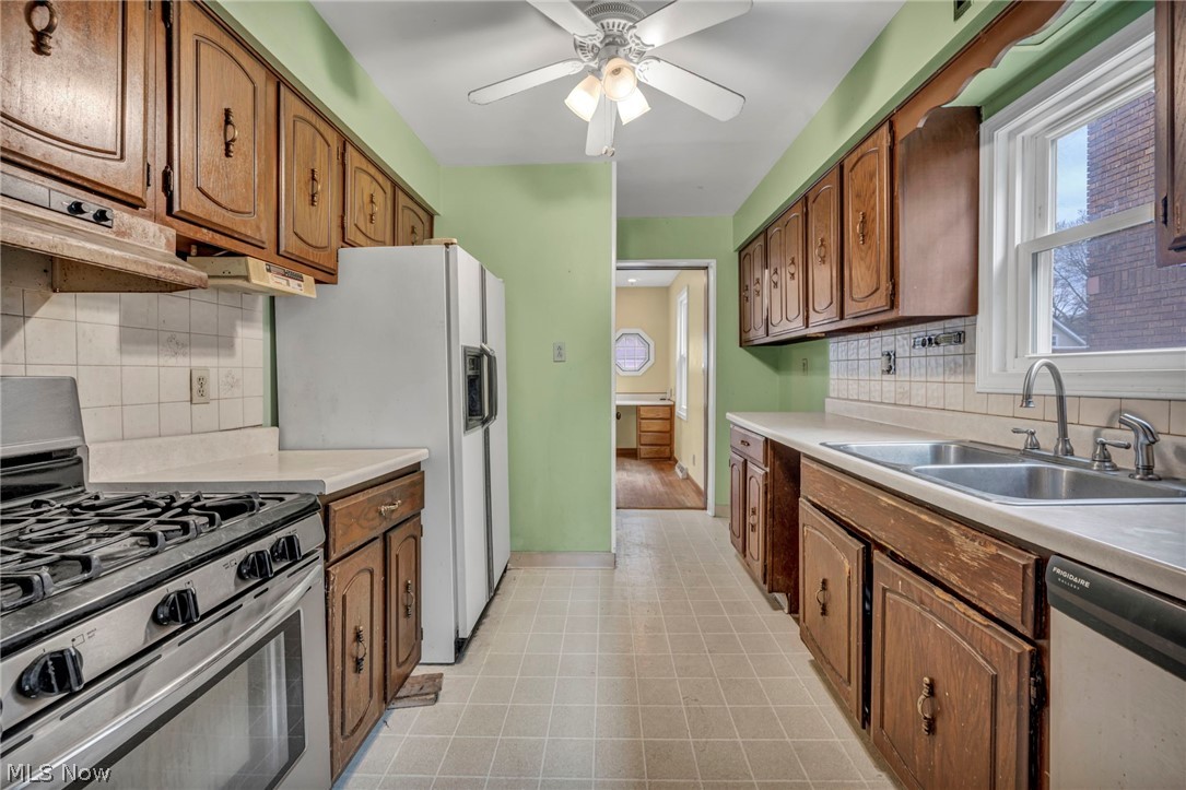 1011 Spring Road Cleveland, OH 44109 - Photo 19 of 47 Kitchen with ceiling fan, stainless steel appliances, tasteful backsplash, sink, and light tile floors