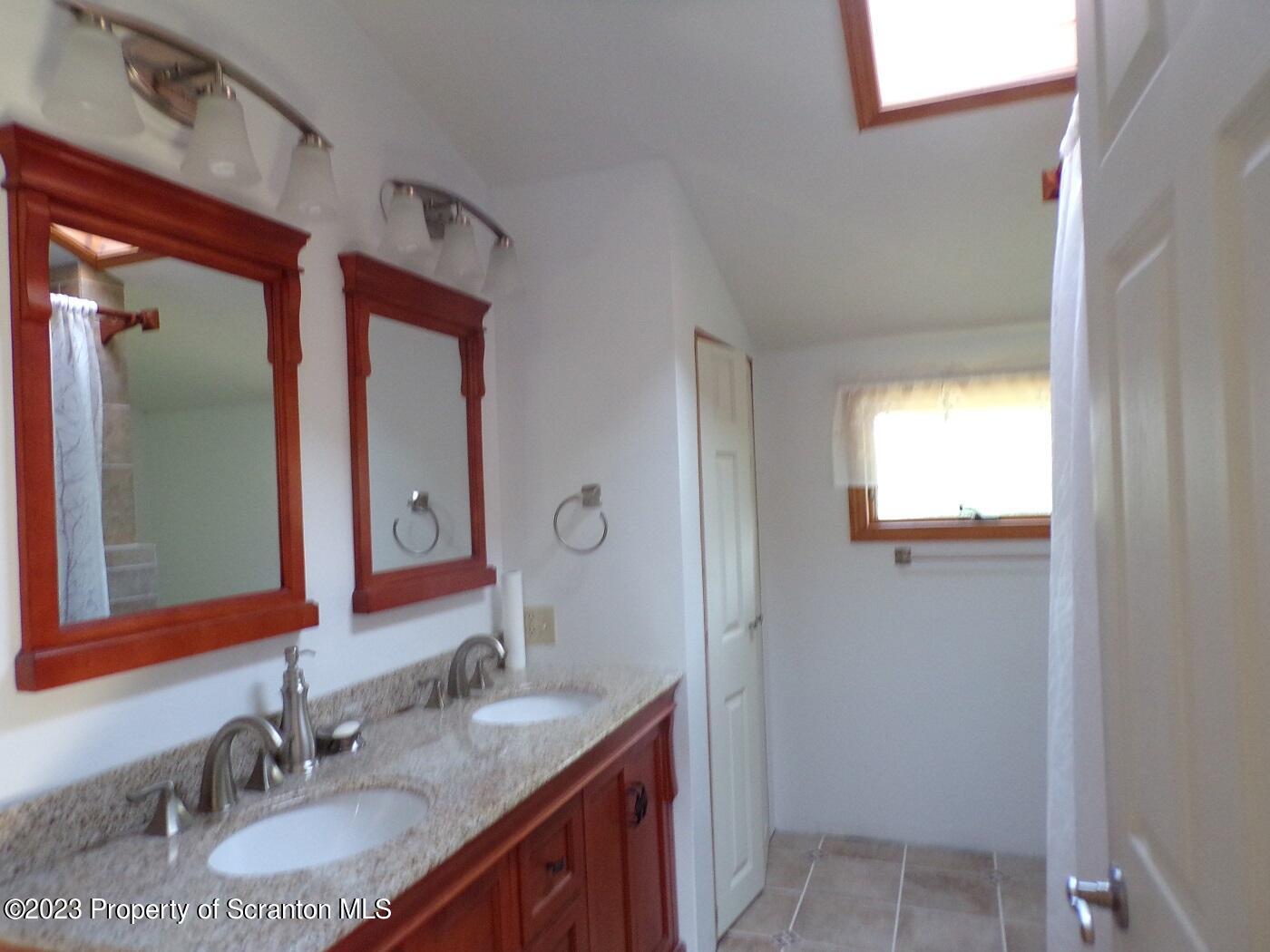 1353 Wright Road Kingsley, PA 18826 - Photo 23 of 31 a bathroom with a granite countertop sink and a mirror