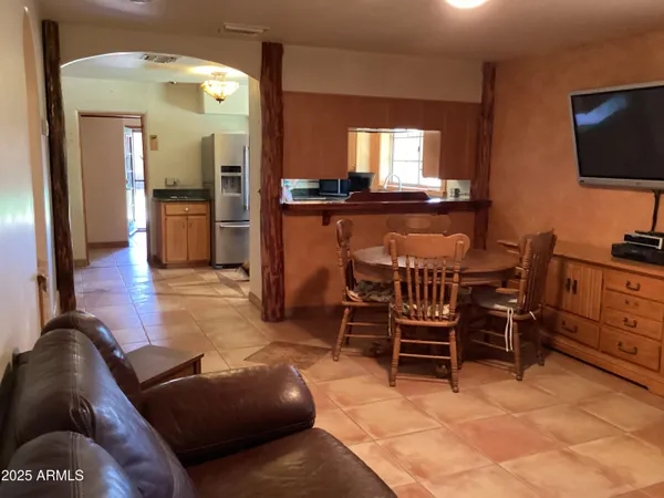 a living room with furniture a flat screen tv and kitchen view