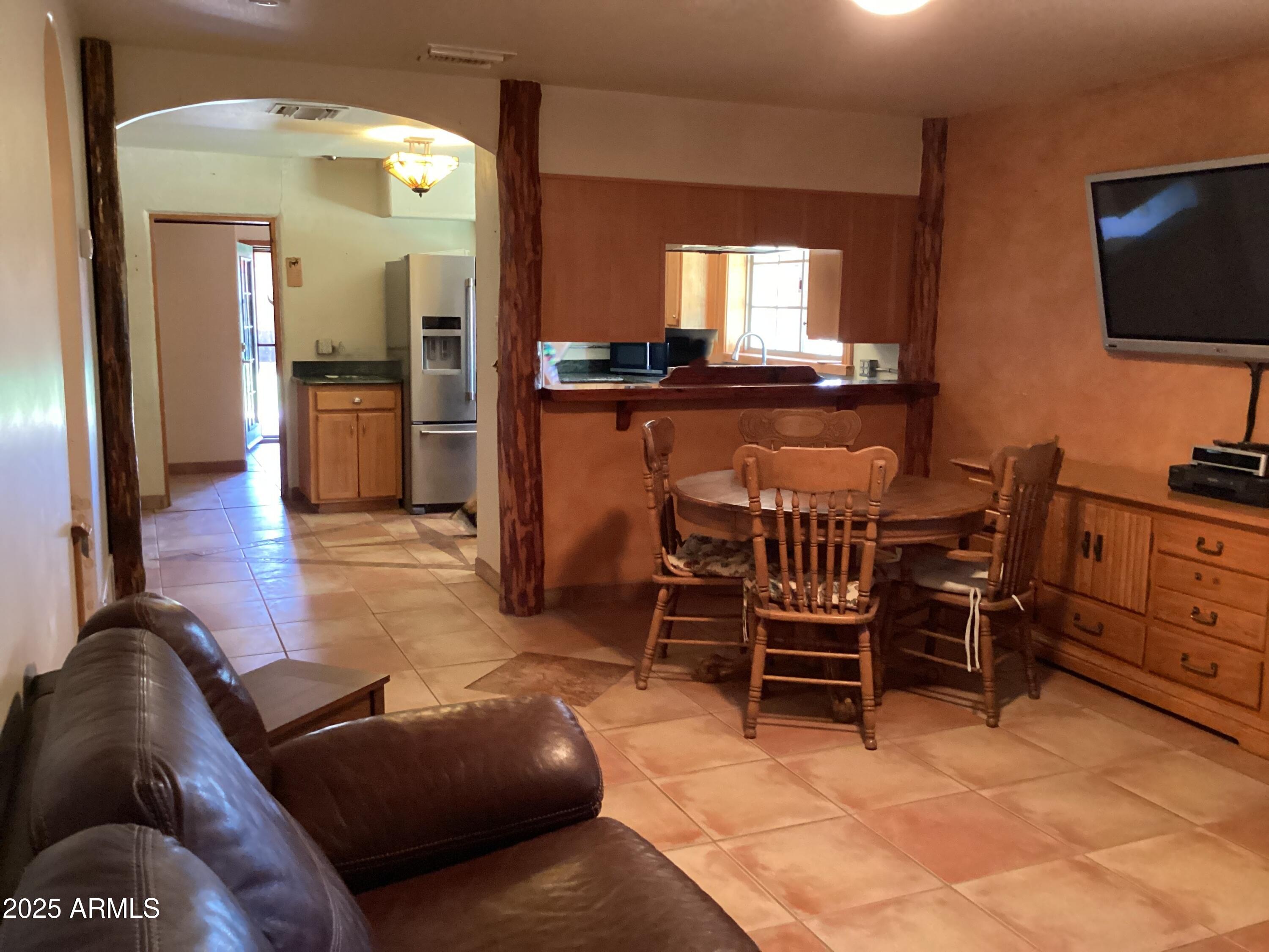 10023 North Bell Road Elfrida, AZ 85610 - Photo 8 of 51 a living room with furniture a flat screen tv and kitchen view