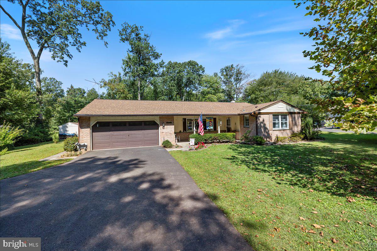 a front view of a house with yard and green space