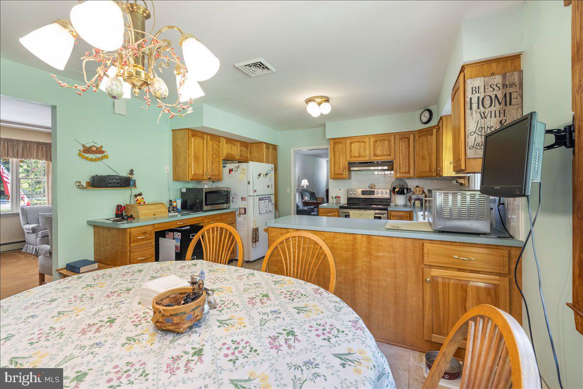 1714 Moyers Road Hatfield, PA 19440 - Photo 7 of 31 a kitchen with stainless steel appliances wooden floor dining table and chandelier