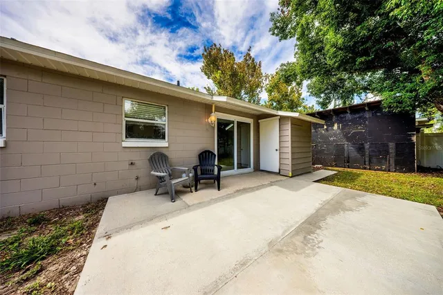 a backyard of a house with table and chairs