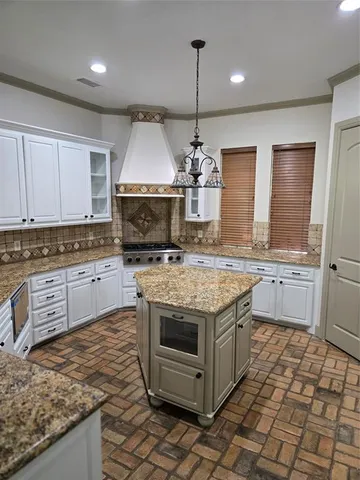 a kitchen with stainless steel appliances granite countertop a stove a sink and a wooden cabinets