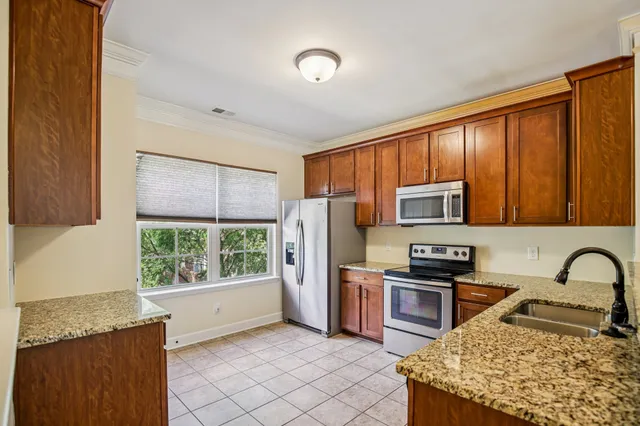 a kitchen with stainless steel appliances granite countertop a refrigerator stove top oven a sink and dishwasher