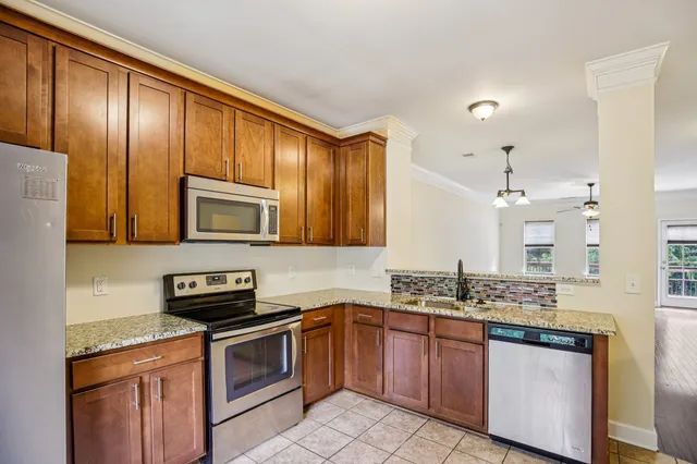 a kitchen with stainless steel appliances granite countertop a sink stove and microwave