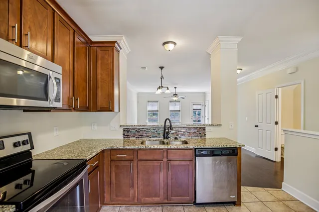 a kitchen with stainless steel appliances granite countertop a sink and a stove