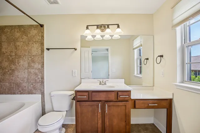 a bathroom with a sink vanity mirror and toilet