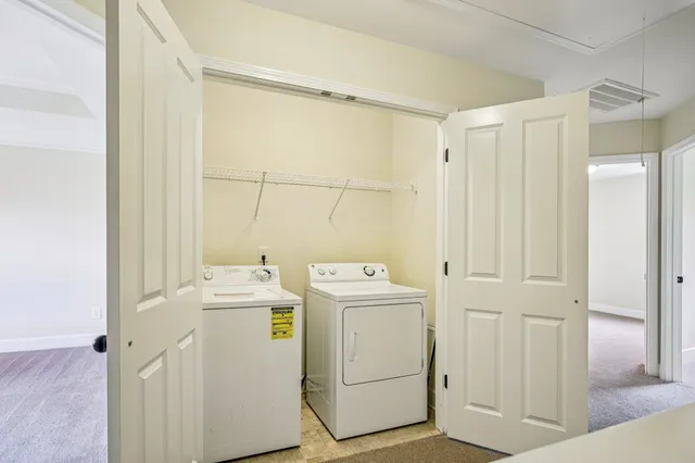a view of washer and dryer with bathroom in the background