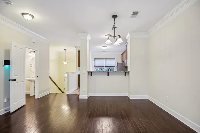 a view of a room with wooden floor and kitchen view