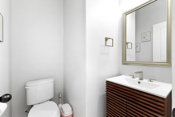 a bathroom with a sink a toilet and mirror