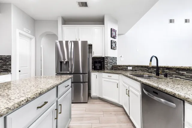 a kitchen with stainless steel appliances granite countertop a sink stove and refrigerator