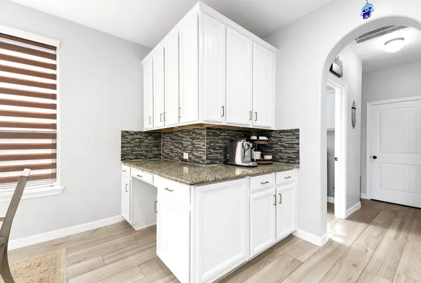 a kitchen with stainless steel appliances granite countertop a stove a sink and white cabinets