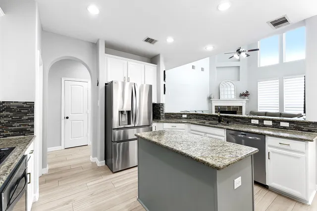 a kitchen with granite countertop a sink stove and refrigerator