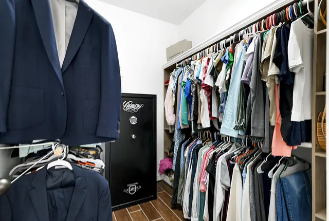 a view of walk in closet with clothes and shoes