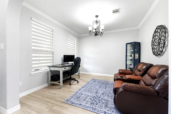 a work room with furniture wooden floor and a window