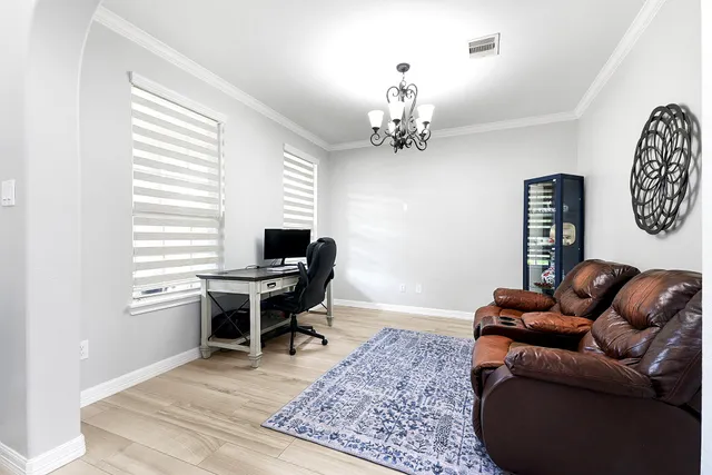 a work room with furniture wooden floor and a window