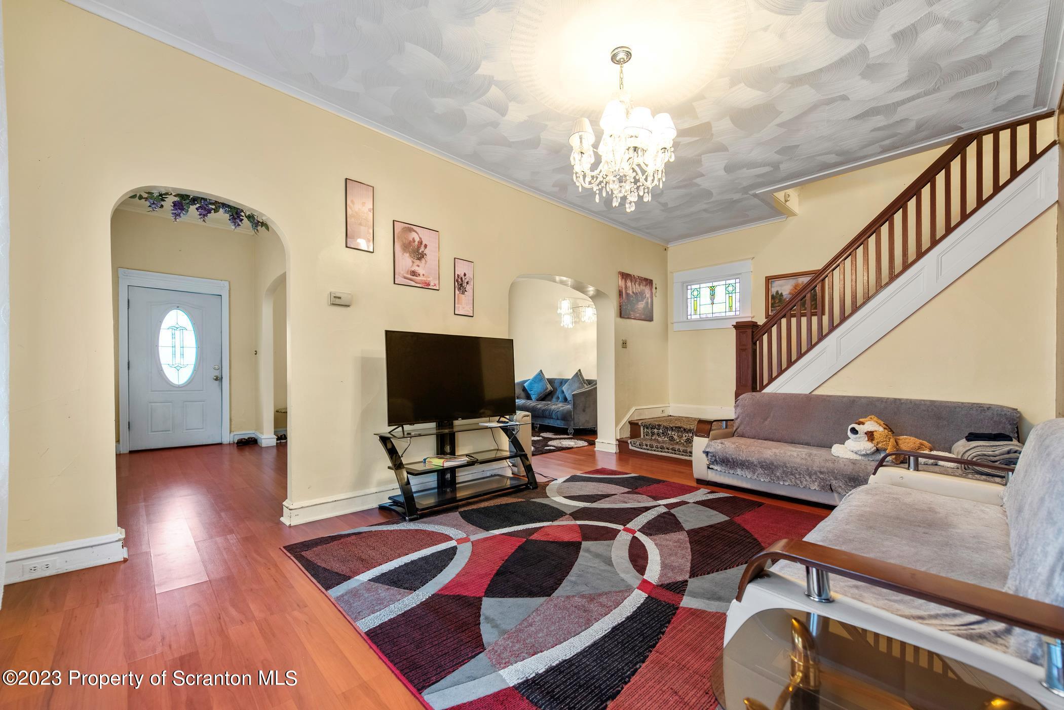 726 Hickory Street Scranton, PA 18505 - Photo 7 of 26 a living room with furniture a dining table and a chandelier