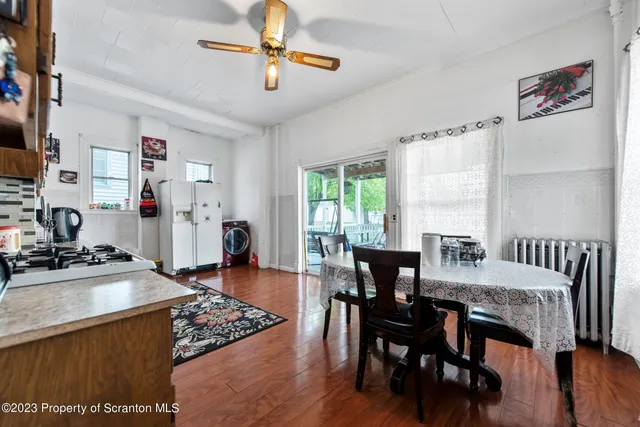 a view of a dining room with furniture a chandelier and wooden floor