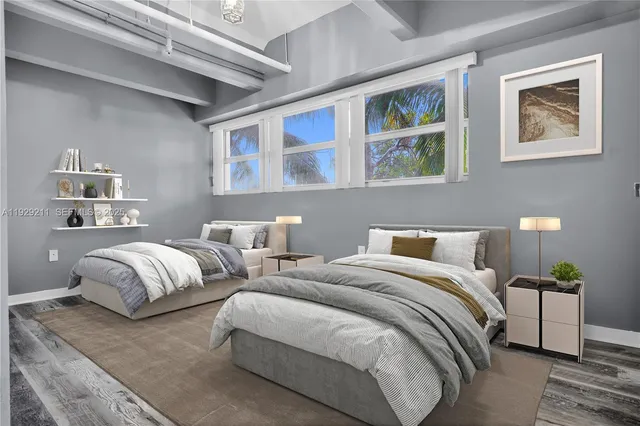 a bedroom with two beds and painting on the wall