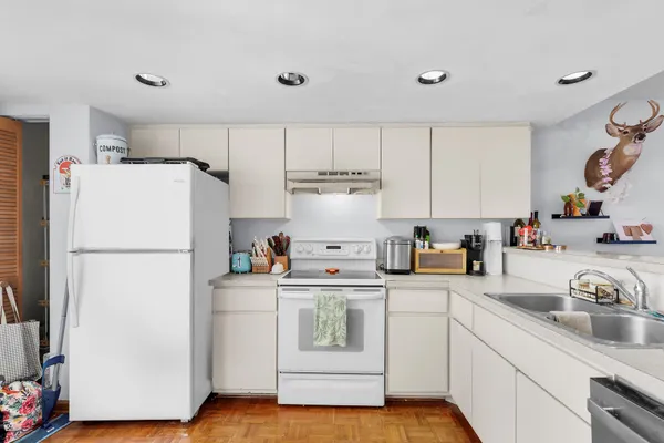 a kitchen with a refrigerator sink and cabinets