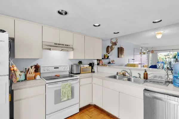 a kitchen with sink cabinets and white appliances