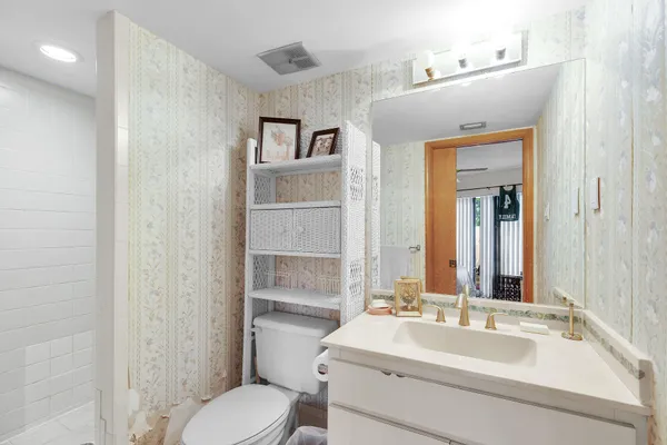 a bathroom with a sink vanity mirror and toilet