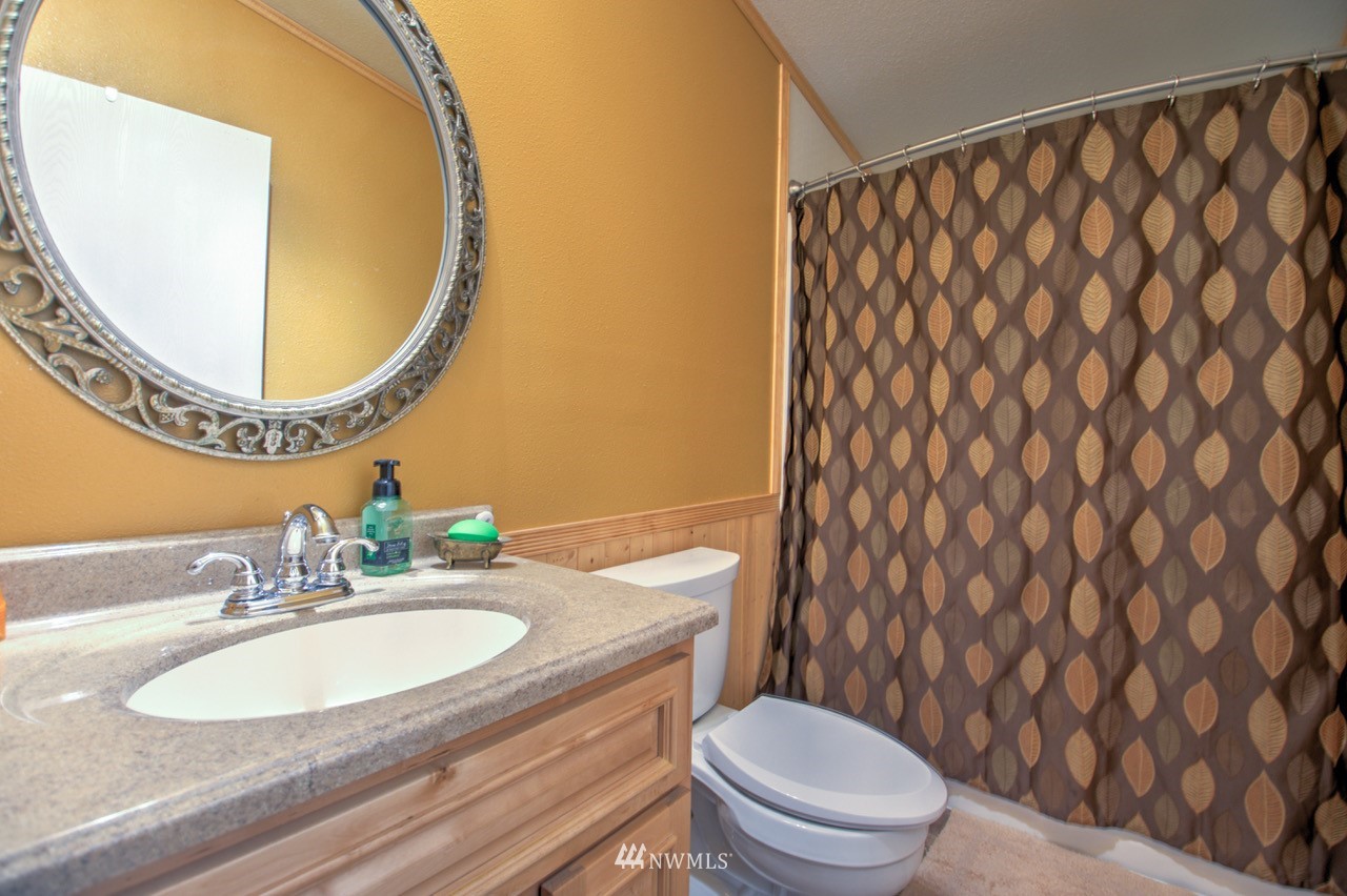 18101 Canaday Lane Southwest Rochester, WA 98579 - Photo 13 of 32 a bathroom with a granite countertop sink and a mirror