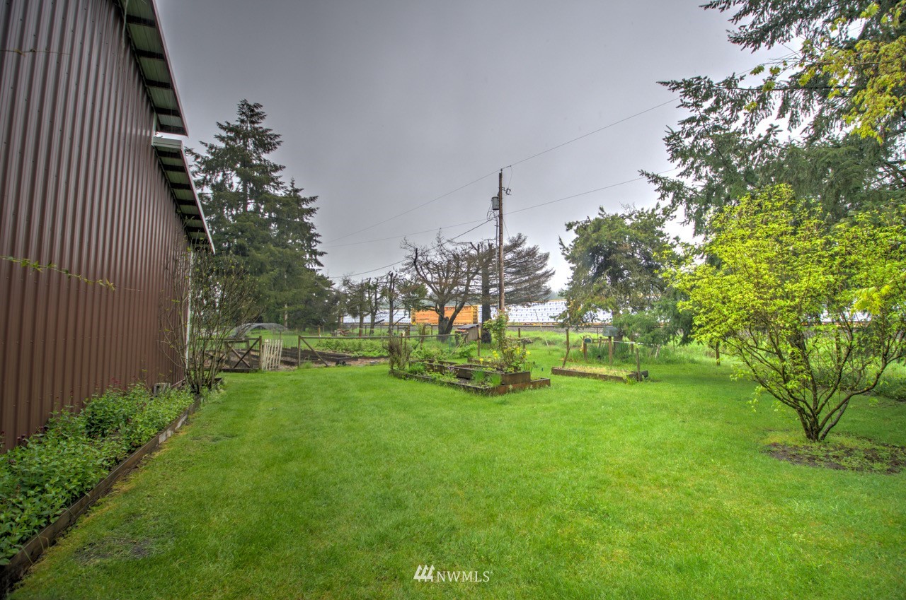 18101 Canaday Lane Southwest Rochester, WA 98579 - Photo 21 of 32 a garden with trees in front of it