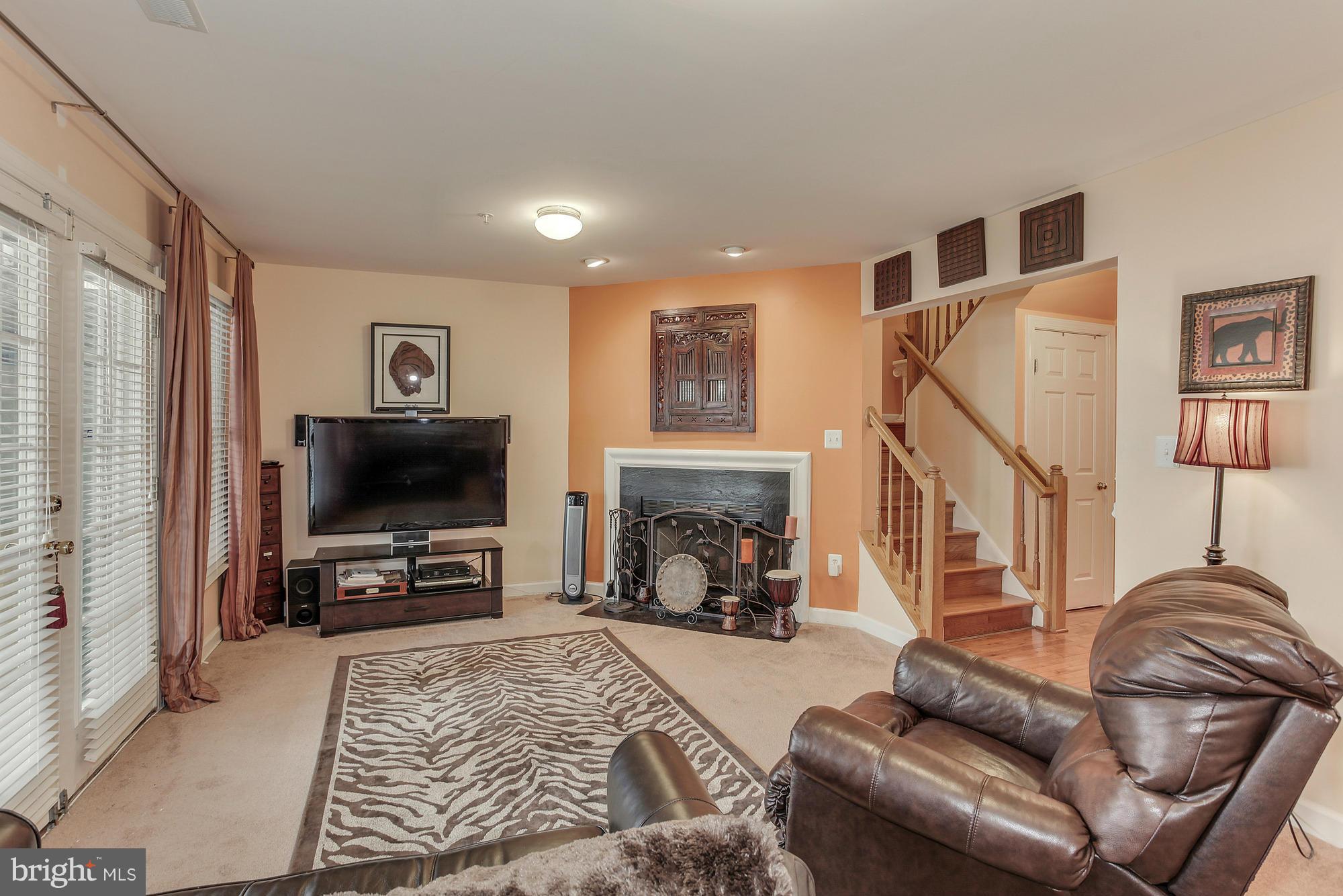 3504 Hammerstone Road Laurel, MD 20724 - Photo 6 of 30 a living room with furniture a flat screen tv and a fireplace