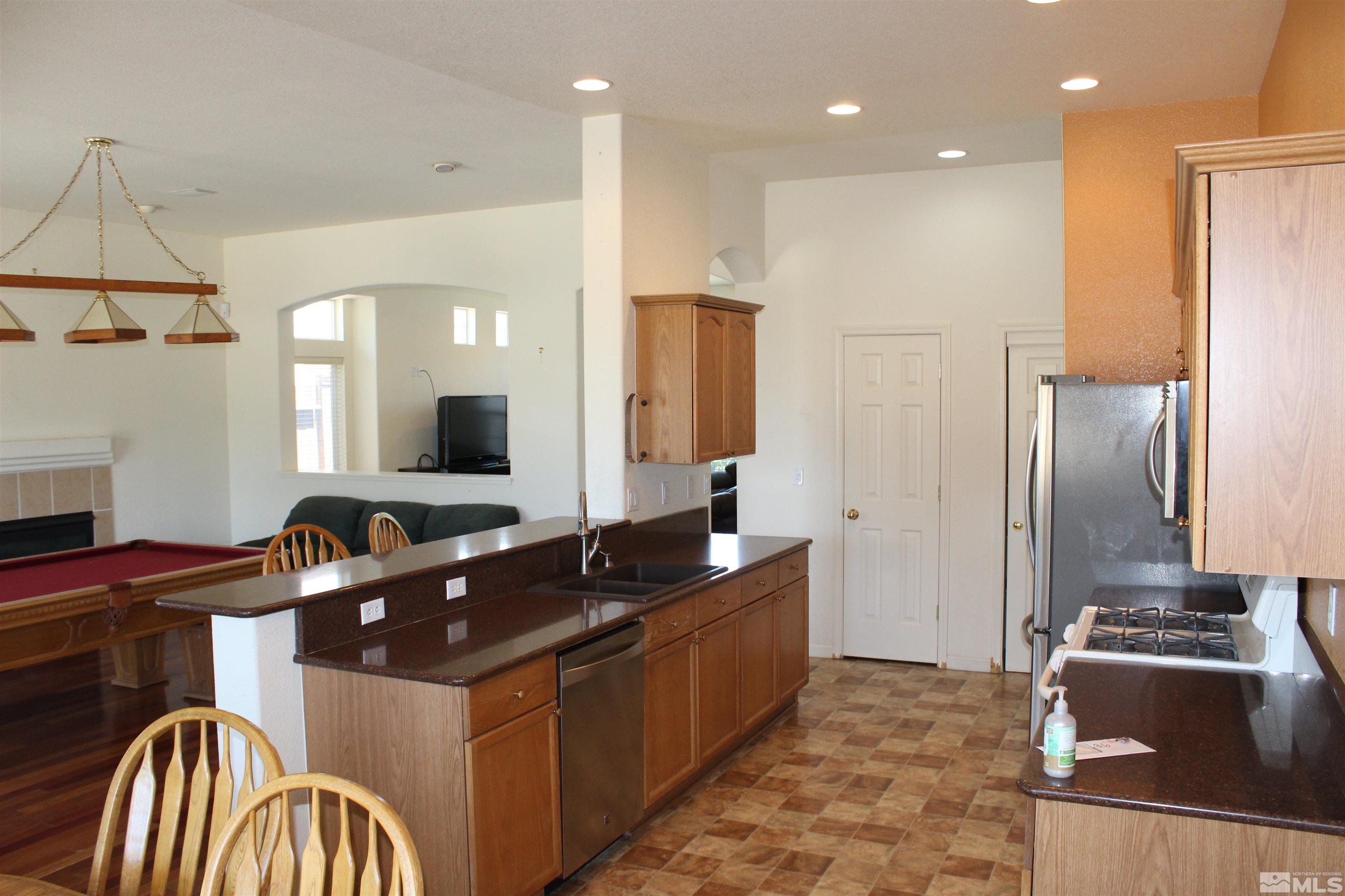 9533 Steep Climb Court Reno, NV 89521 - Photo 6 of 15 a kitchen with stainless steel appliances granite countertop a sink and a refrigerator