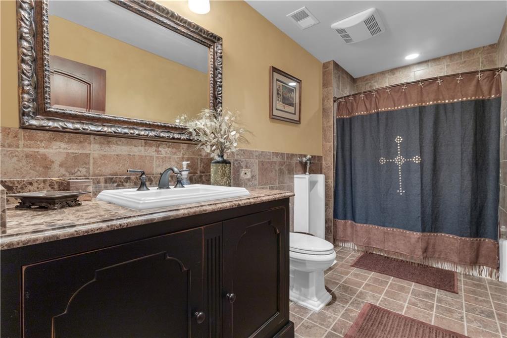 14501 Woolsey Road Hampton, GA 30228 - Photo 66 of 143 a spacious bathroom with a granite countertop sink toilet and shower