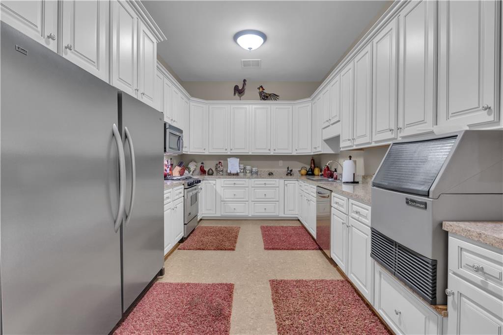 14501 Woolsey Road Hampton, GA 30228 - Photo 90 of 143 a kitchen with cabinets and stainless steel appliances