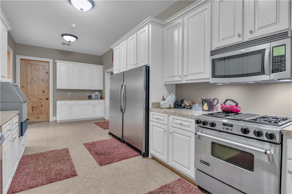 14501 Woolsey Road Hampton, GA 30228 - Photo 91 of 143 a kitchen with stainless steel appliances granite countertop a refrigerator stove and white cabinets