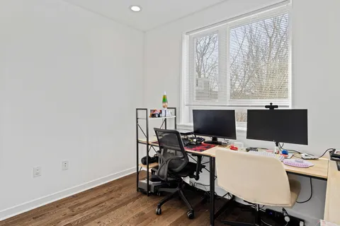 a view of a workspace with furniture and a window