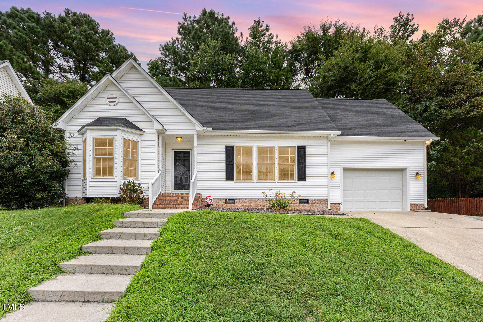 a front view of a house with a yard and trees