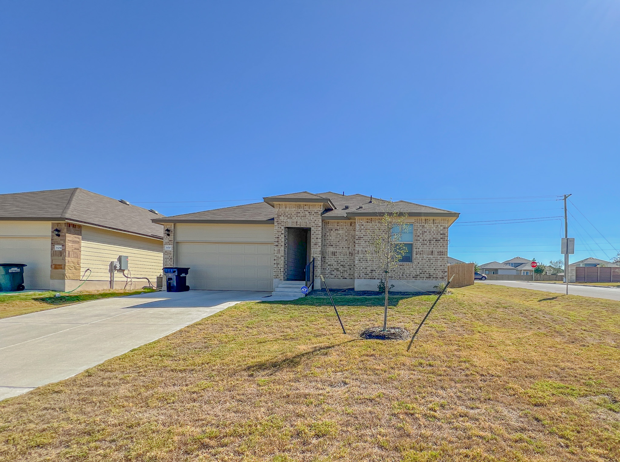 100 Taggart Trail Jarrell, TX 76537 - Photo 3 of 18 View of front of house with a front yard, concrete driveway, brick siding, and an attached garage
