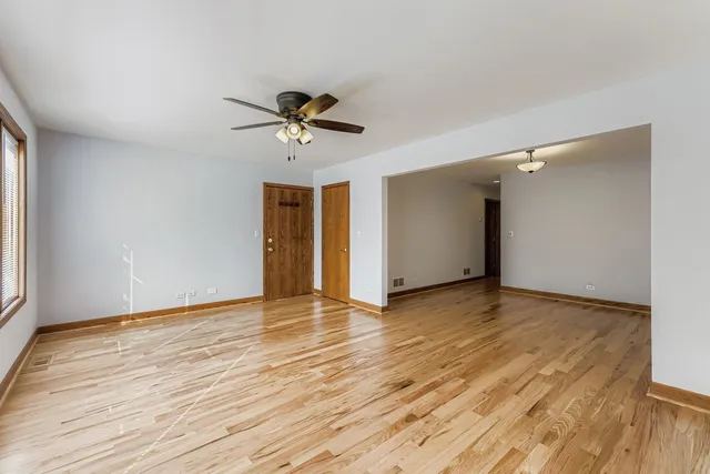 a view of room with wooden floor and ceiling fan