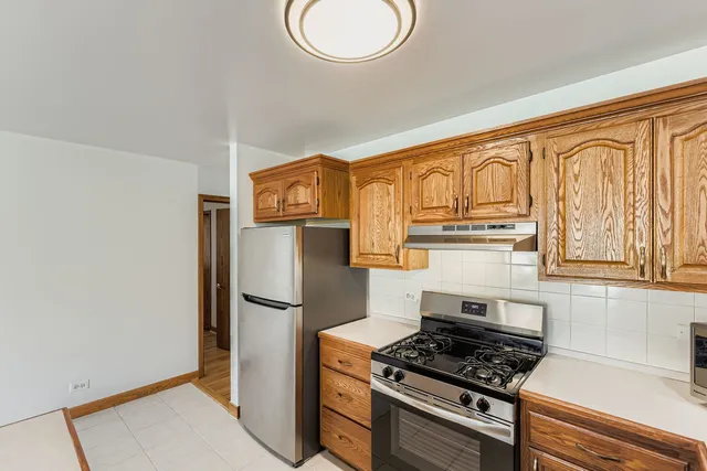 a kitchen with stainless steel appliances granite countertop a refrigerator a stove and a sink