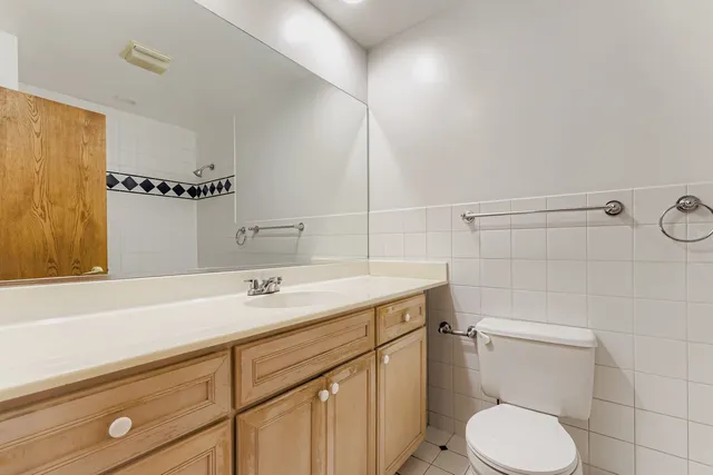 a bathroom with a granite countertop toilet sink and mirror