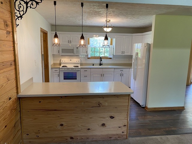398 Azbill Road Lexington, TN 38351 - Photo 15 of 40 a kitchen with kitchen island granite countertop counter top space a sink stainless steel appliances and cabinets