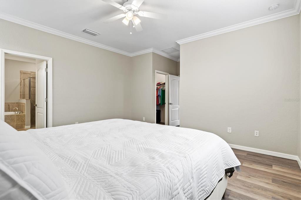 17030 Blue Ridge Place Bradenton, FL 34211 - Photo 20 of 65 a bedroom with a bed and a chandelier