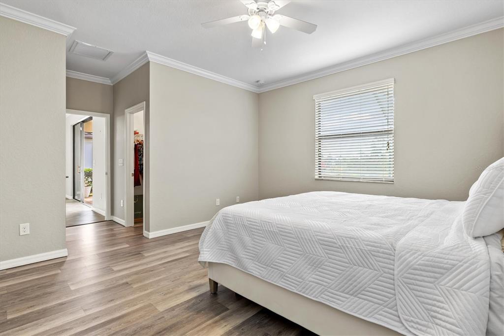 17030 Blue Ridge Place Bradenton, FL 34211 - Photo 21 of 65 a bedroom with a large bed a chandelier and a window