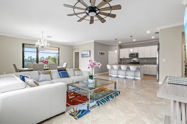 a living room with furniture a chandelier and a window