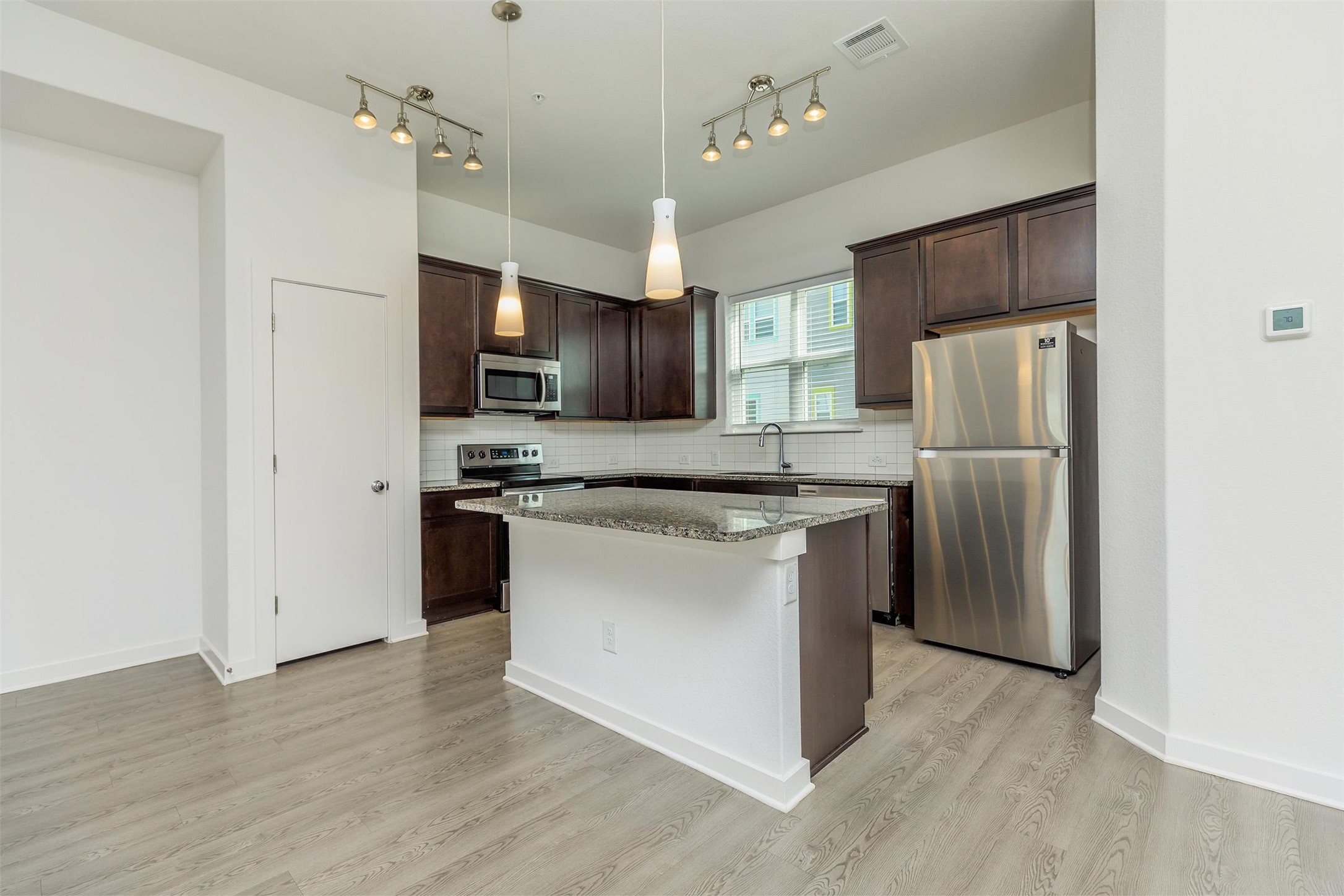 428 Ozark Trail Leander, TX 78641 - Photo 2 of 27 a kitchen with stainless steel appliances granite countertop a refrigerator stove microwave and sink
