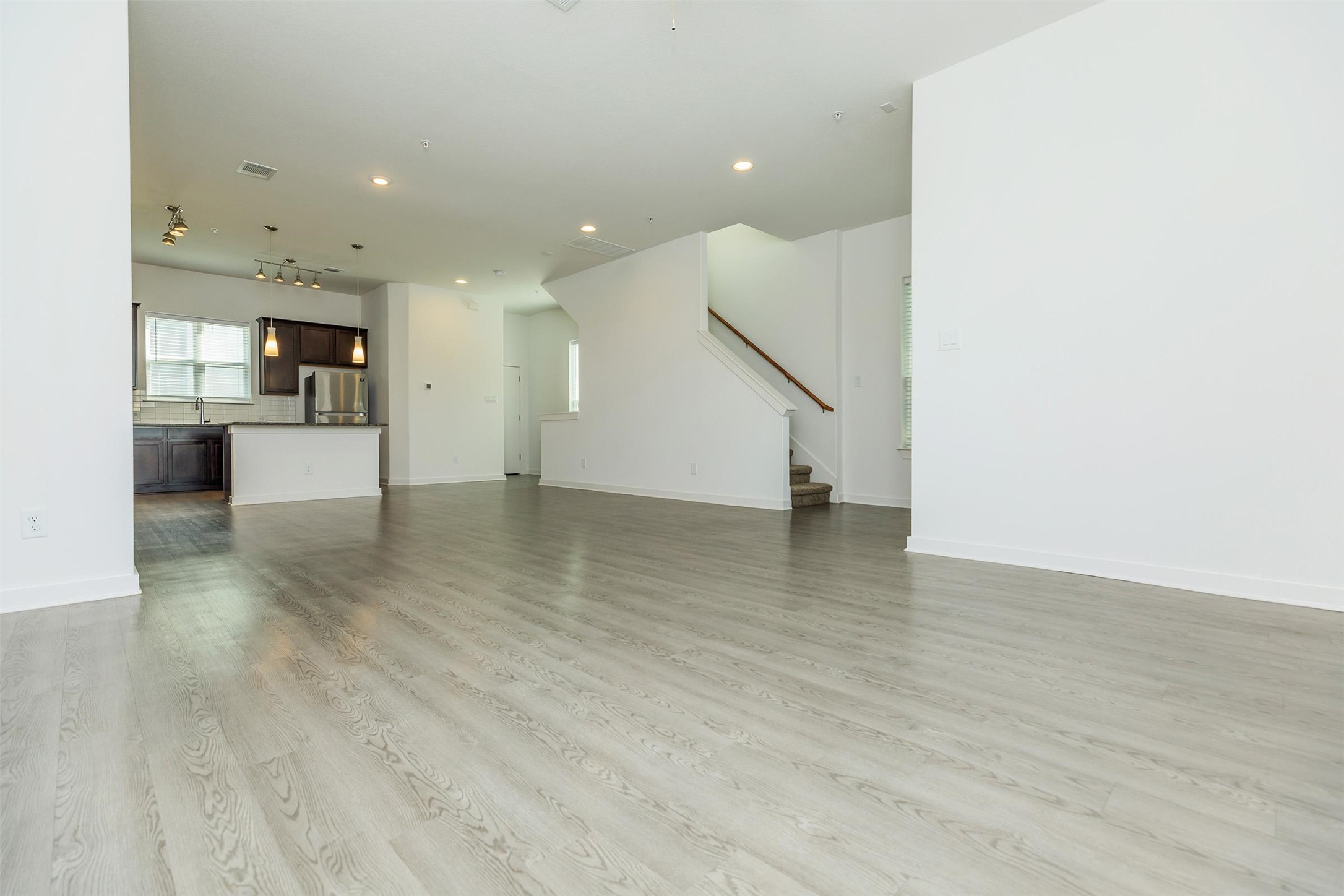 428 Ozark Trail Leander, TX 78641 - Photo 5 of 27 an empty room with wooden floor and a kitchen