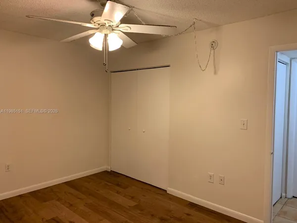 a view of a small space with wooden floor and a ceiling fan