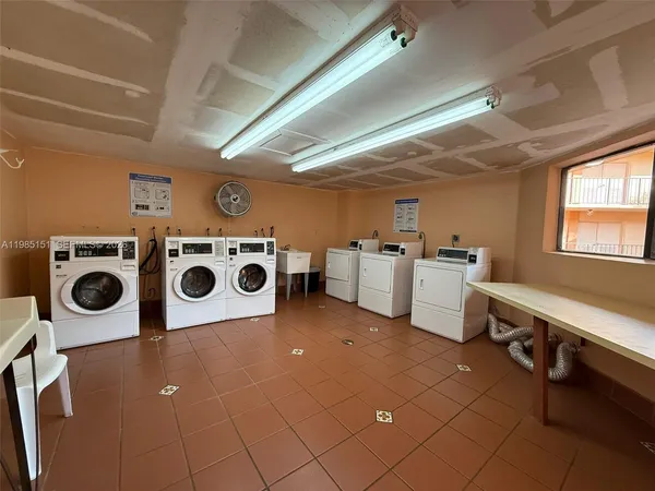 a utility room with dryer washer and a view of living room