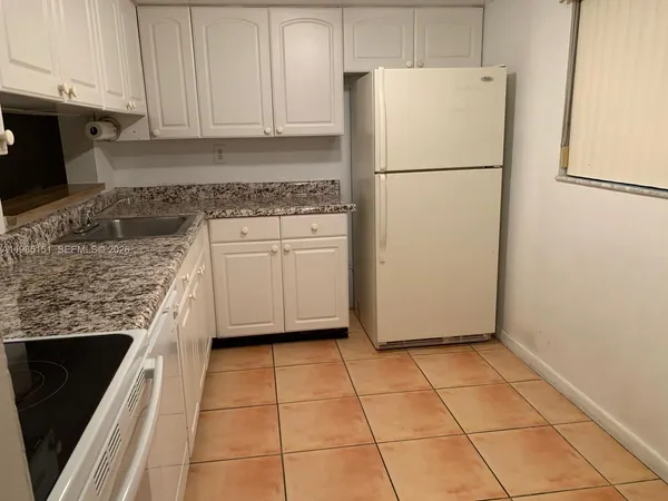 a kitchen with a refrigerator a stove a microwave and cabinets